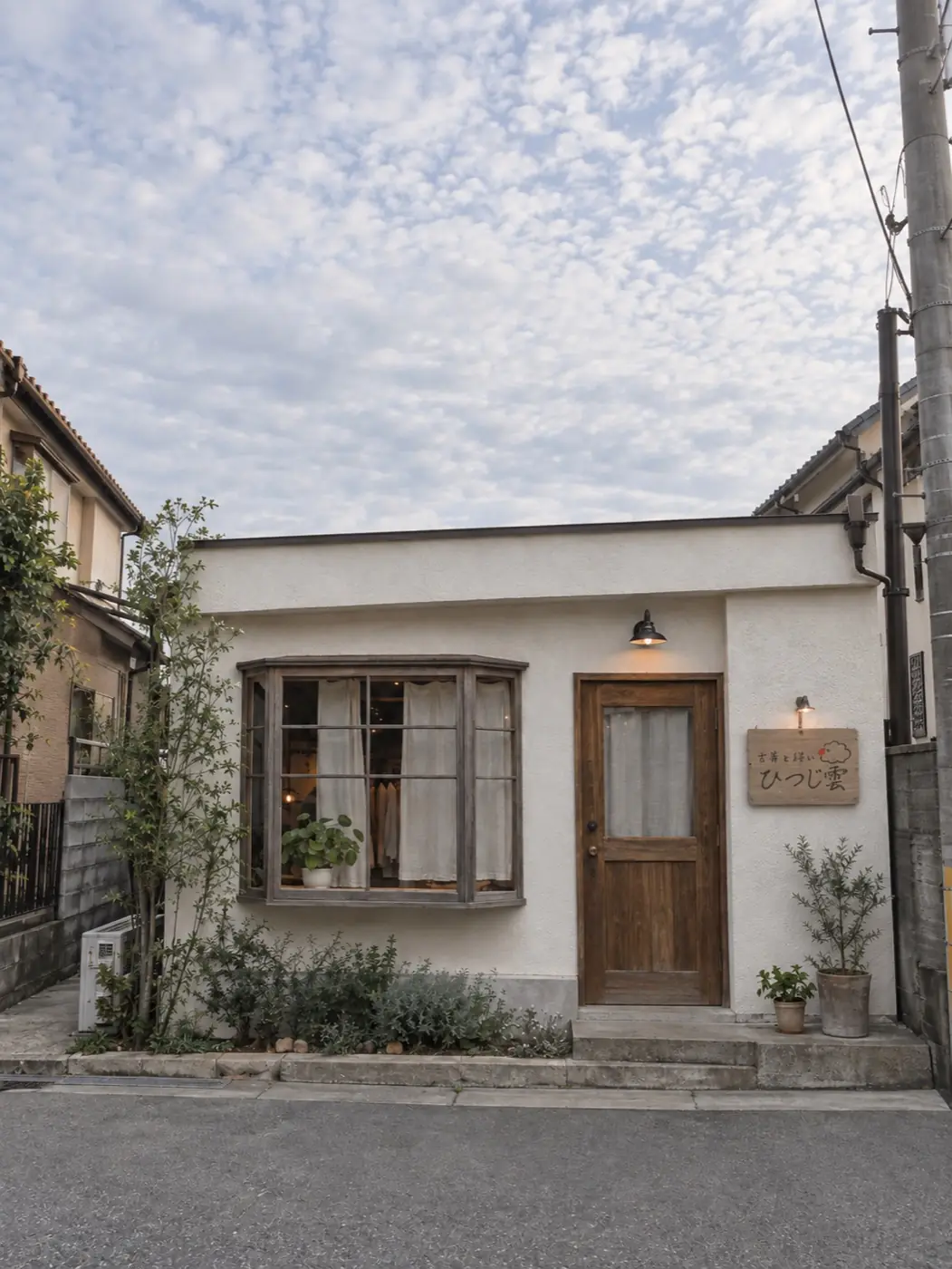 住宅街の一角にある、白い壁と木の扉の小さな店